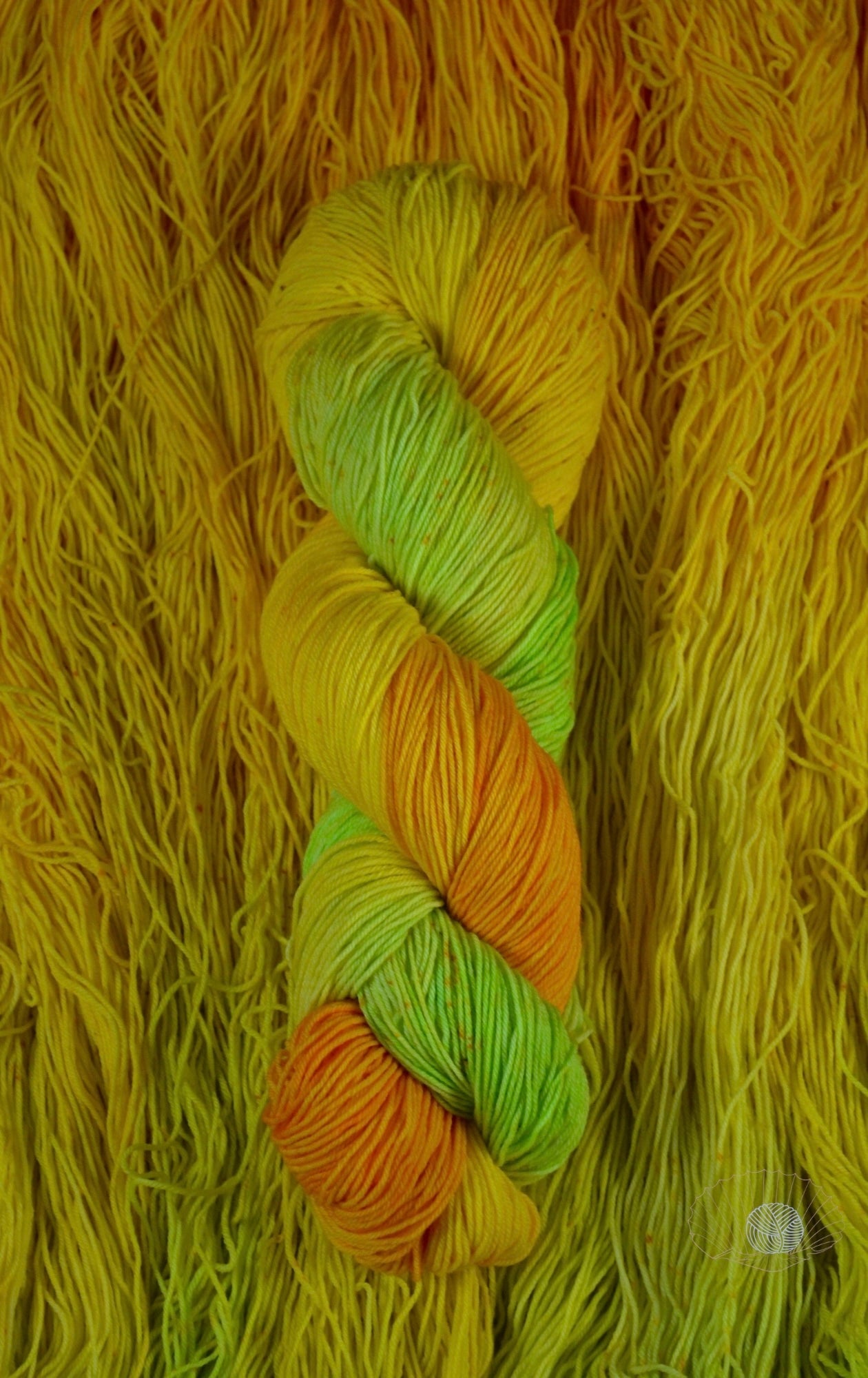 A gradient of orange to yellow to citron with speckling. Dyed on sock weight yarn.