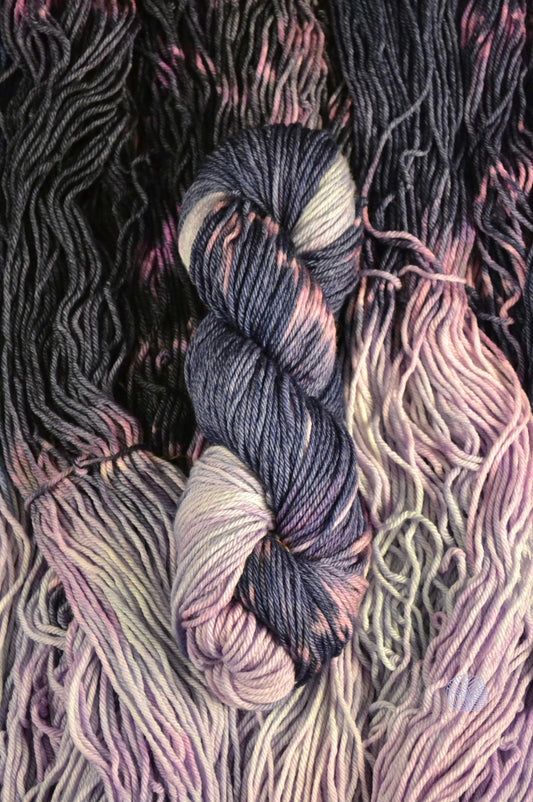 A striping yarn split between a lavender-periwinkle blend and navy with magenta spots. Dyed on worsted weight yarn.