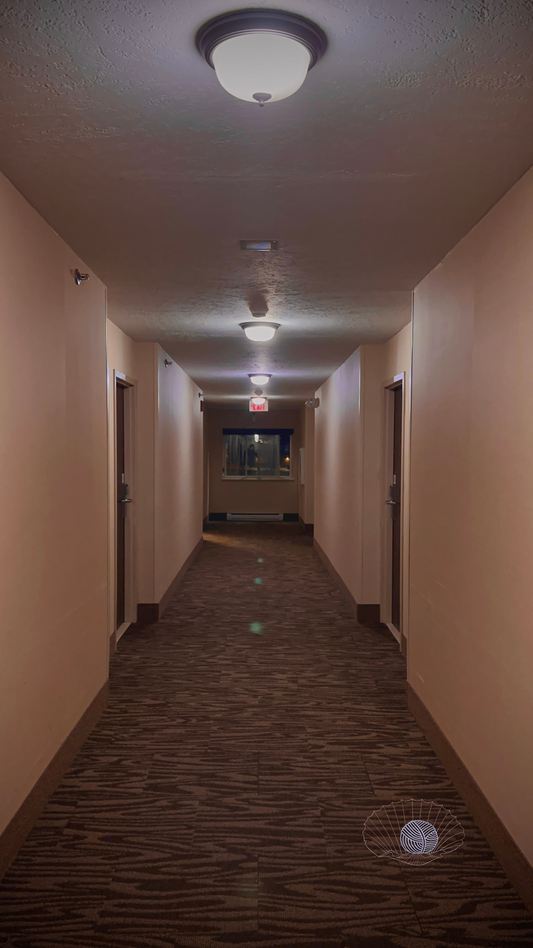 A pink toned beige and brown hotel hallway displaying symmetry